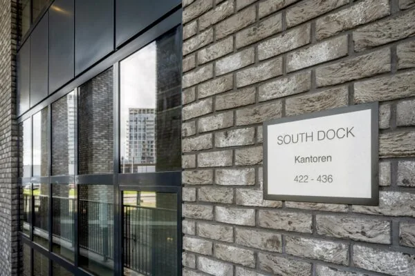 Gevel van het kantoorgebouw South Dock met een bord waarop de adressen 422–436 staan.