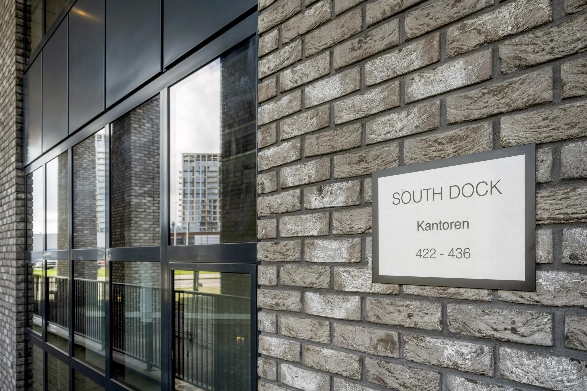Gevel van het kantoorgebouw South Dock met een bord waarop de adressen 422–436 staan.