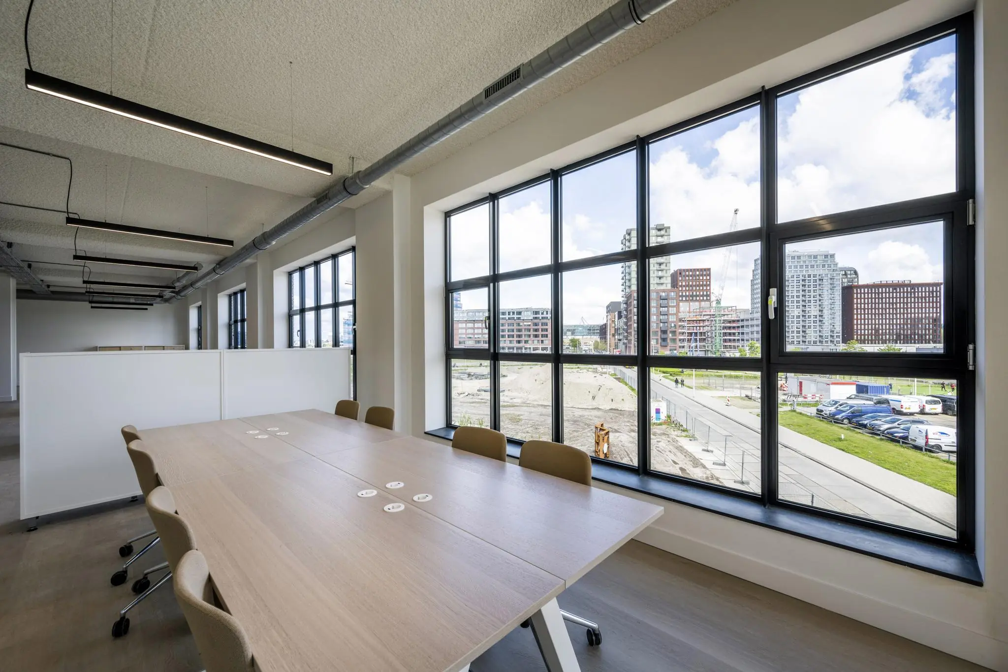 Moderne vergaderruimte met grote ramen en uitzicht op de stadsontwikkeling aan de Hellingbaan.