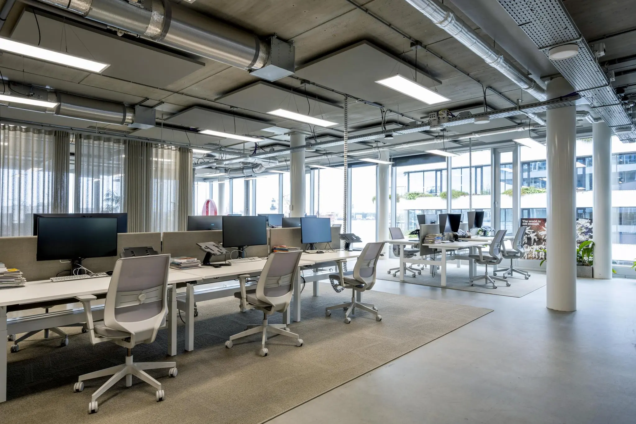 Modern en open kantoorinterieur aan de Moermanskade met werkplekken, bureaustoelen en grote ramen.