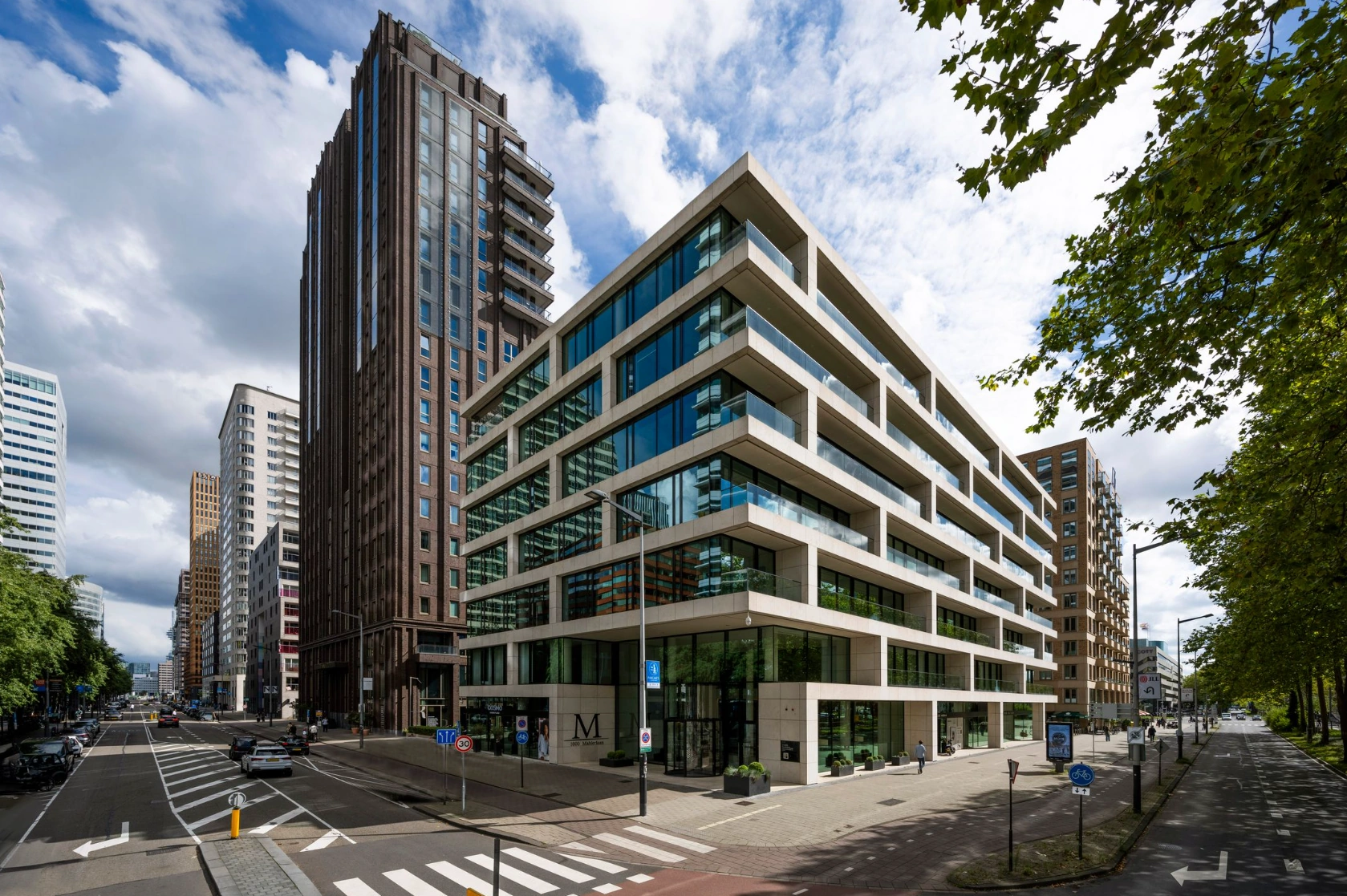 Modern kantoorgebouw aan de Gustav Mahlerlaan in Amsterdam, omringd door hoge torens en brede straten.