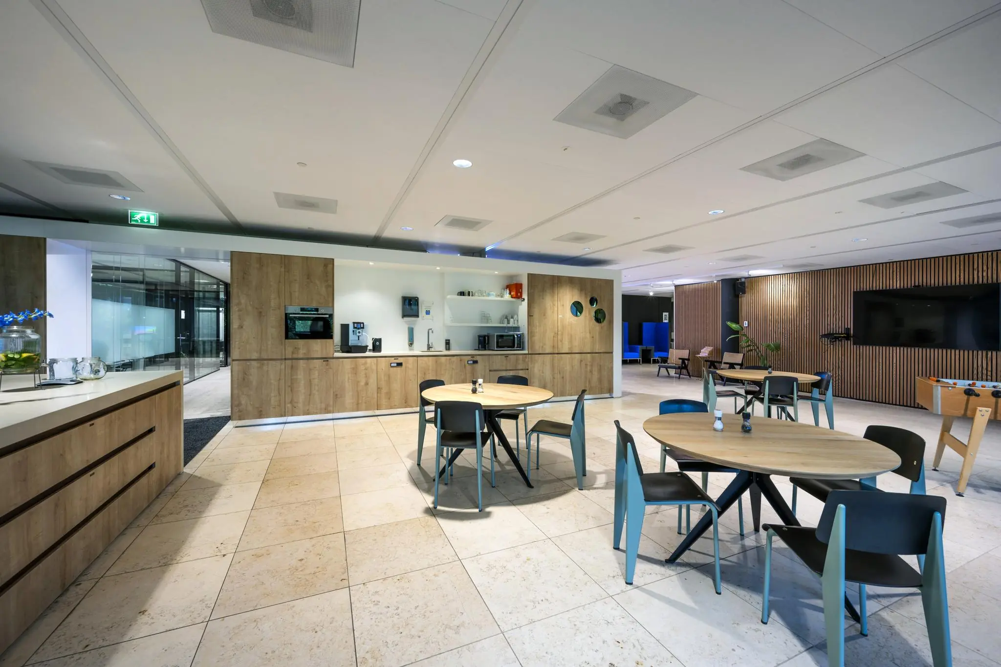 Moderne kantoorruimte aan de Gustav Mahlerlaan met een open kitchenette, zithoeken en een tafelvoetbaltafel.