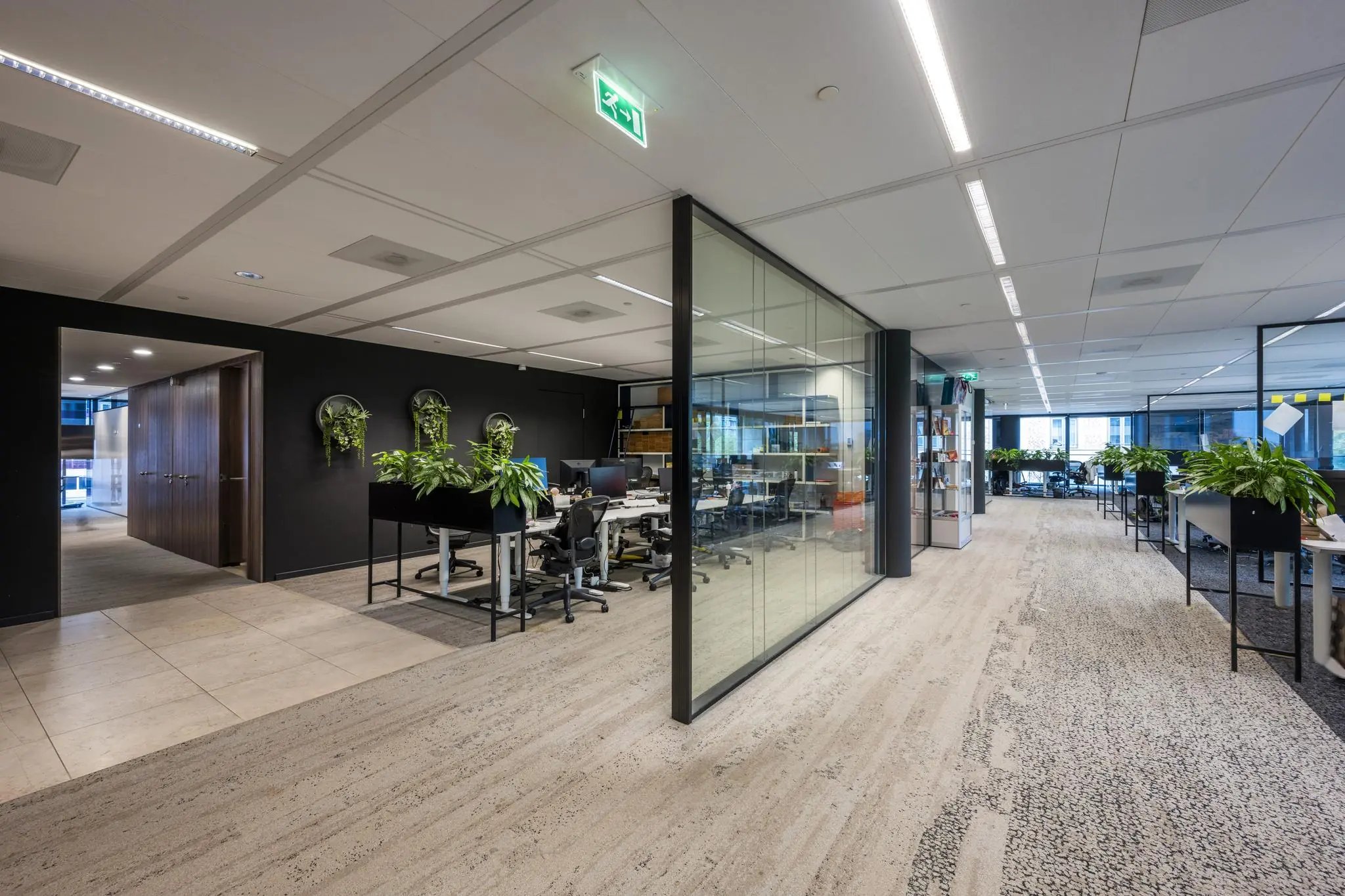 Moderne kantoorruimte aan de Gustav Mahlerlaan met glazen wanden, werkplekken en veel groenvoorziening.