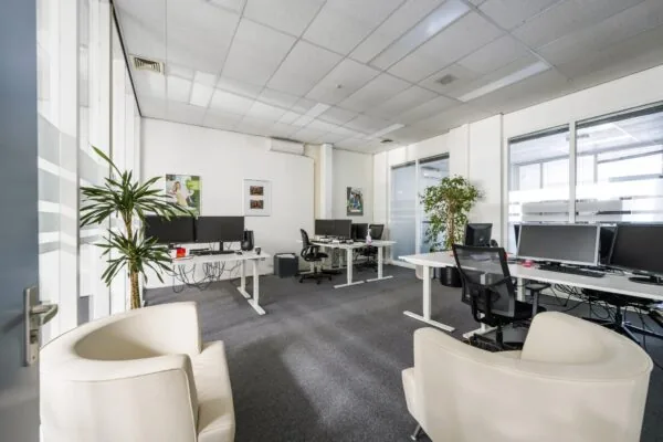 Moderne kantoorruimte aan de Van der Madeweg met meerdere werkplekken, bureaustoelen, beeldschermen en groendecoratie.
