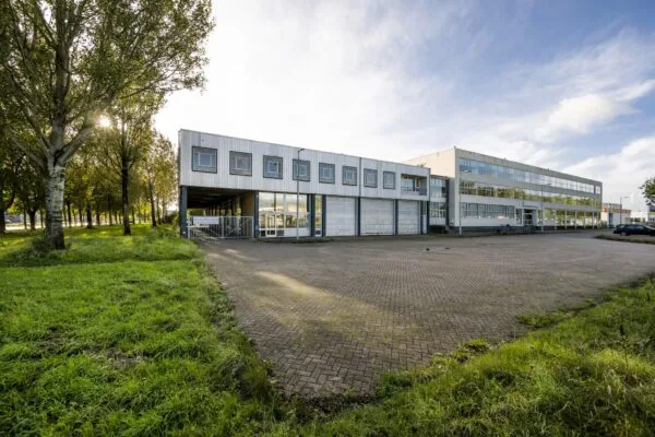 Zakelijk kantoorgebouw aan de Van der Madeweg met ruime parkeerplaats en omringd door groen.