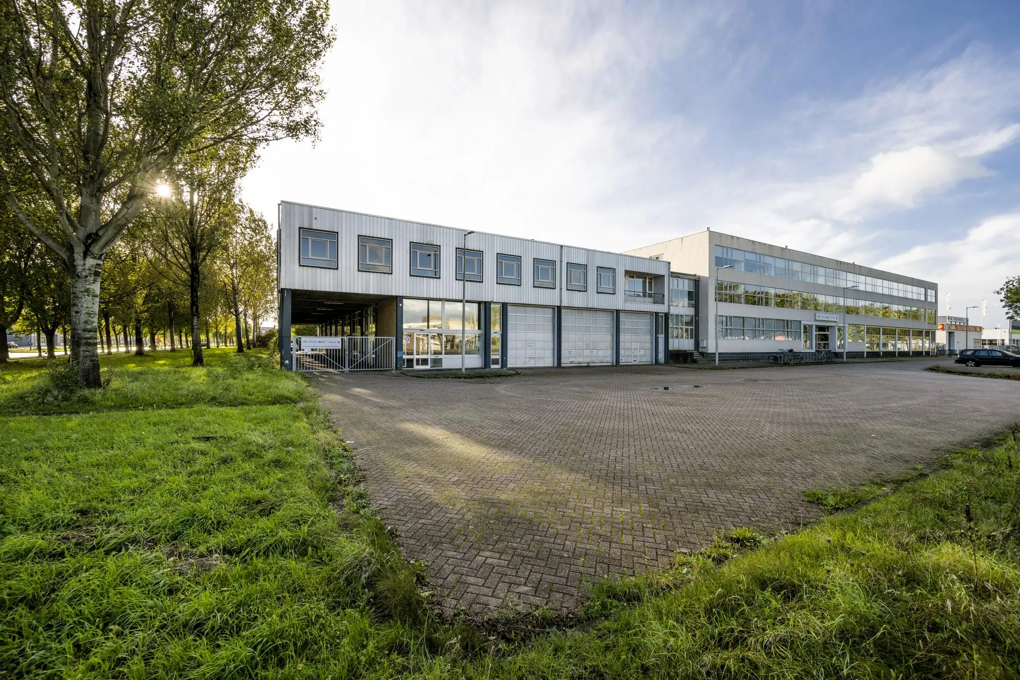 Zakelijk kantoorgebouw aan de Van der Madeweg met ruime parkeerplaats en omringd door groen.