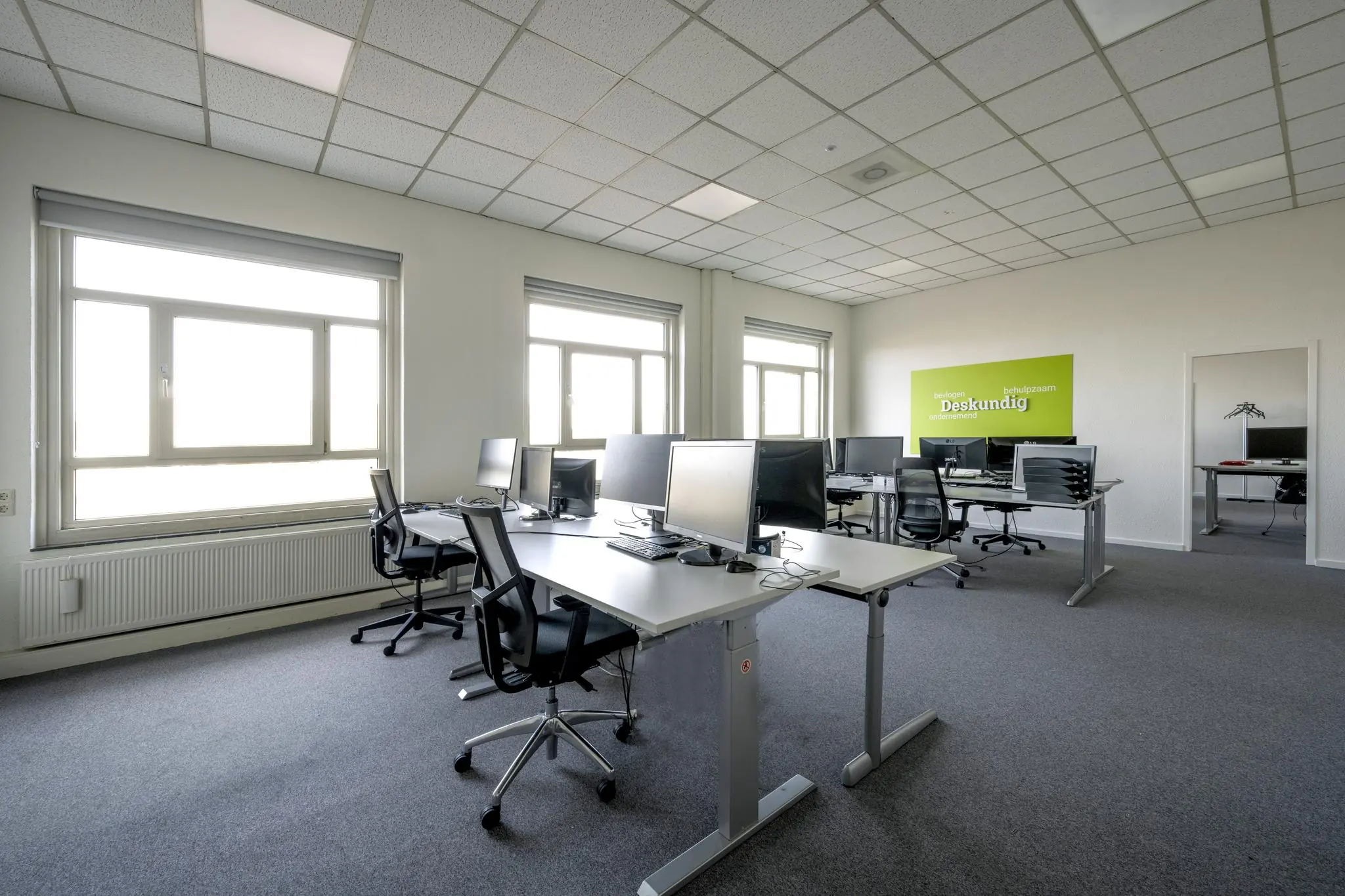 Modern kantoor met meerdere werkplekken, bureaustoelen en computers aan de Van der Madeweg.