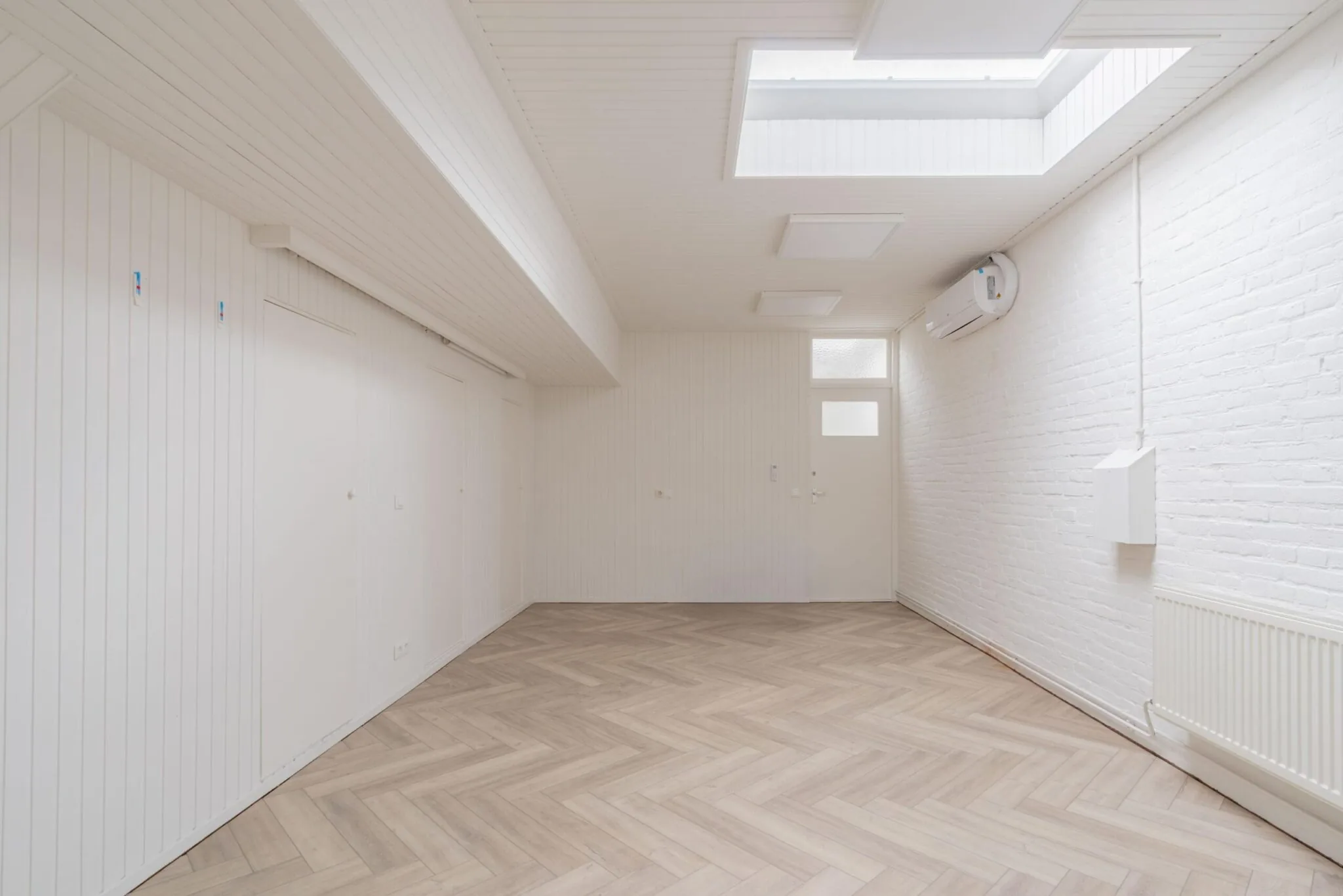 Lichte, lege ruimte aan de Sloterweg met wit houten plafond, visgraatvloer, dakramen en airconditioning.