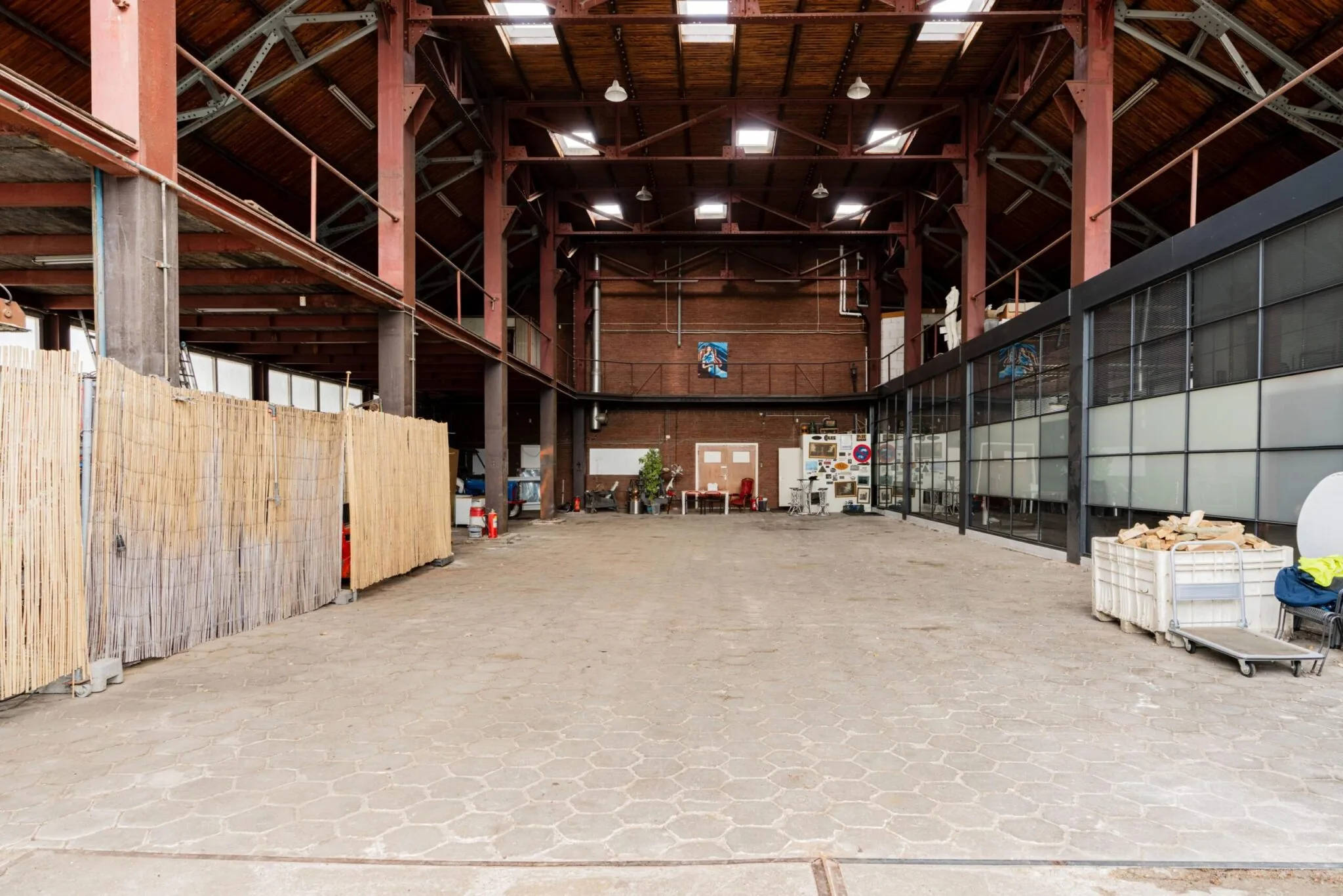 Ruime industriële loods aan de Sloterweg met hoge houten dakconstructie en diverse werkruimtes.