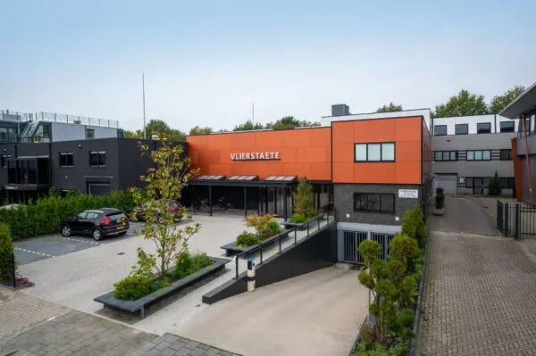 Zakelijk gebouw Vlierstaete met oranje gevel en parkeervoorzieningen aan de Vlierberg.