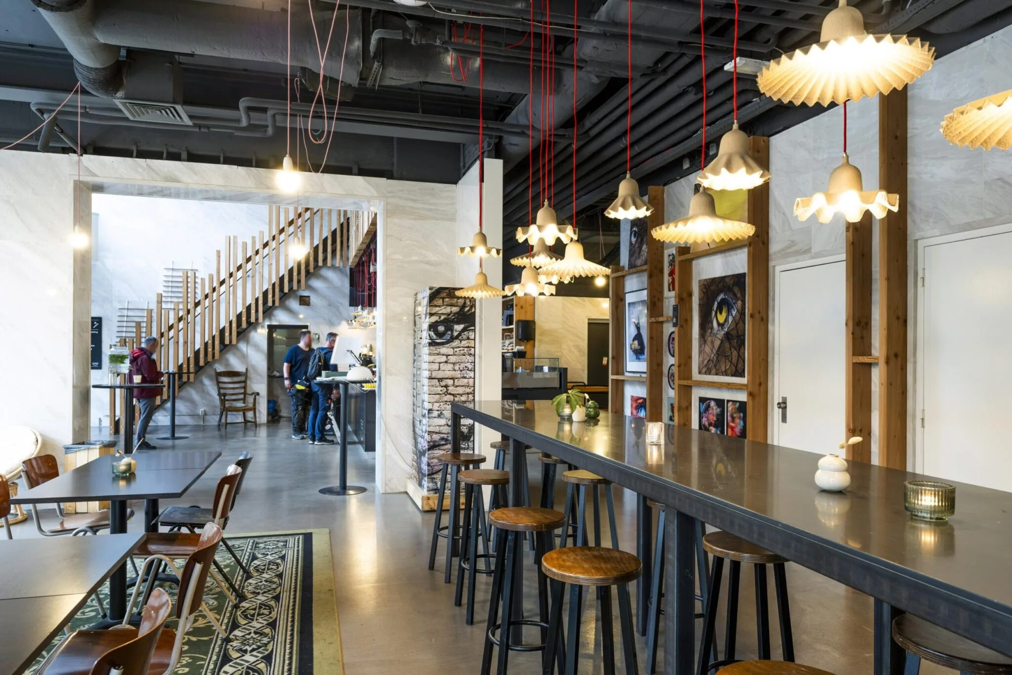 Modern ingerichte horecaruimte op Laan van Kronenburg met industriële details, kunst aan de muur en houten zitplaatsen.