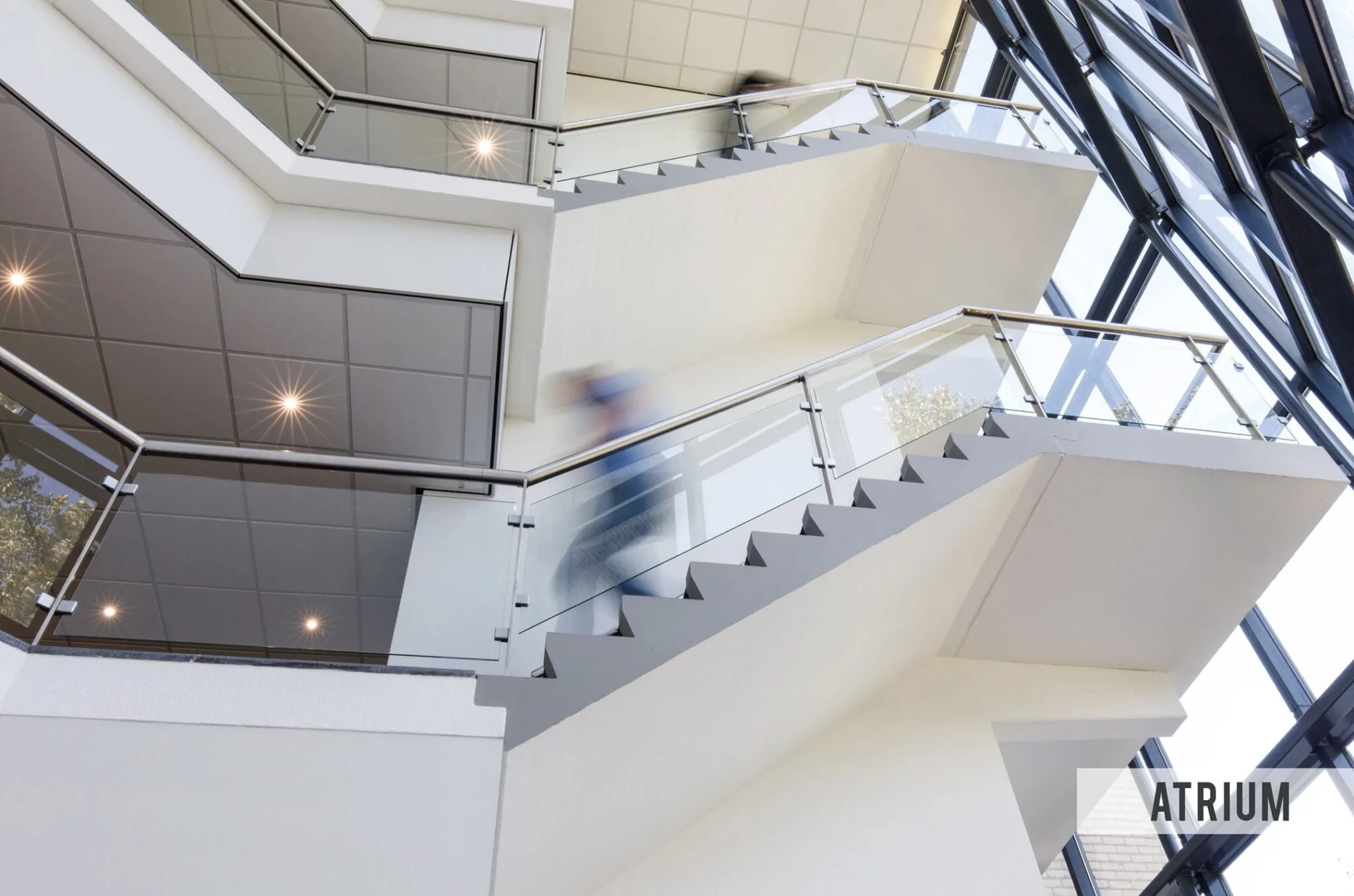 Moderne trap met glazen balustrades in het atrium van een kantoorgebouw aan de Baarnsche Dijk.