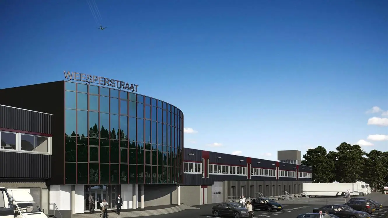Modern bedrijfspand aan de Weesperstraat met glazen gevel en parkeerterrein op de voorgrond.