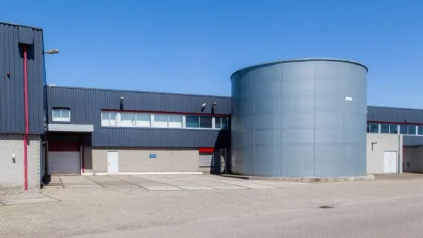 Bedrijventerrein met een modern industrieel gebouw en een grote ronde metalen silo aan de Weesperstraat.