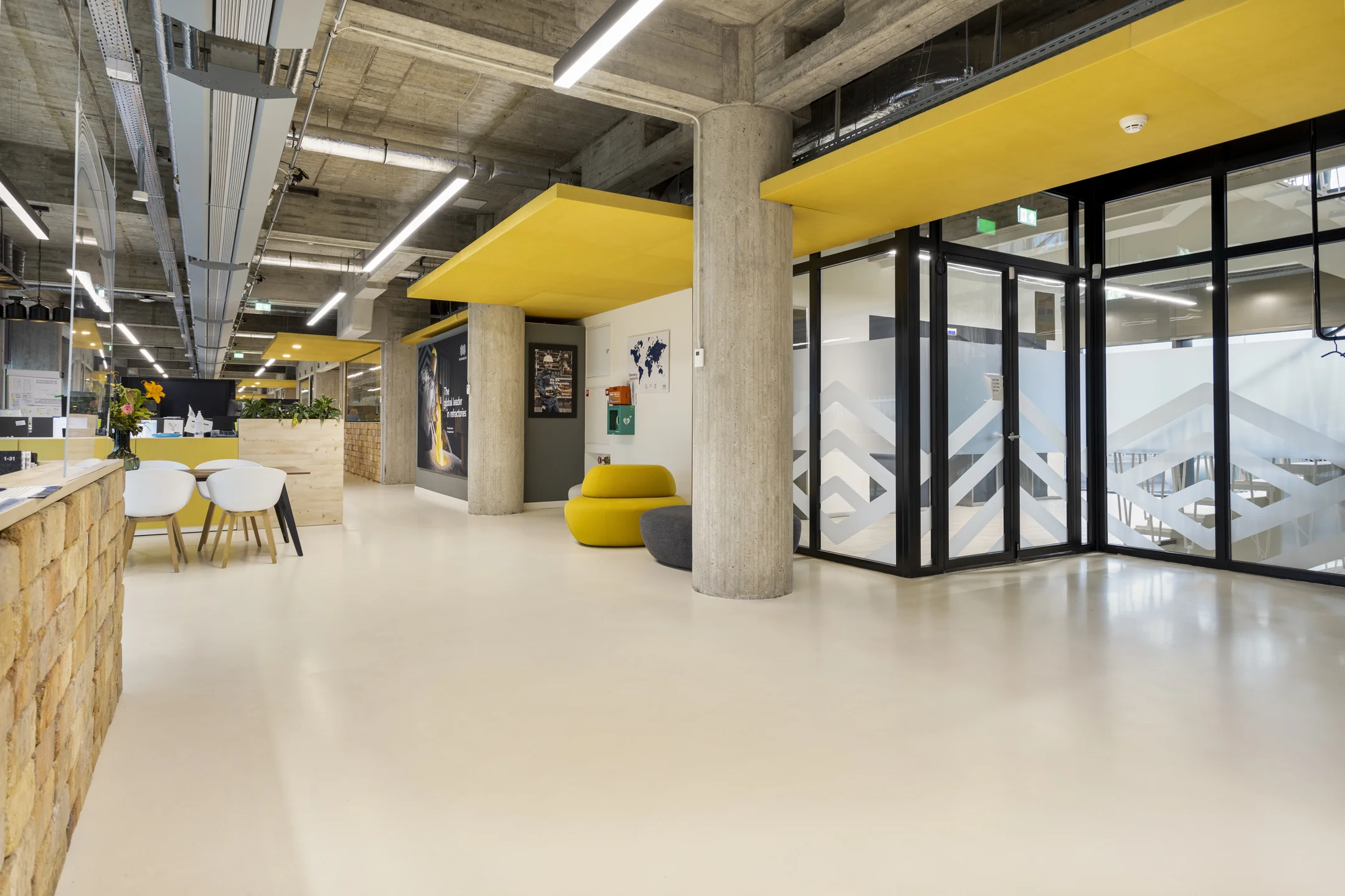 Een modern kantoorinterieur op Hofplein met gele en grijze accenten en glaspanelen.