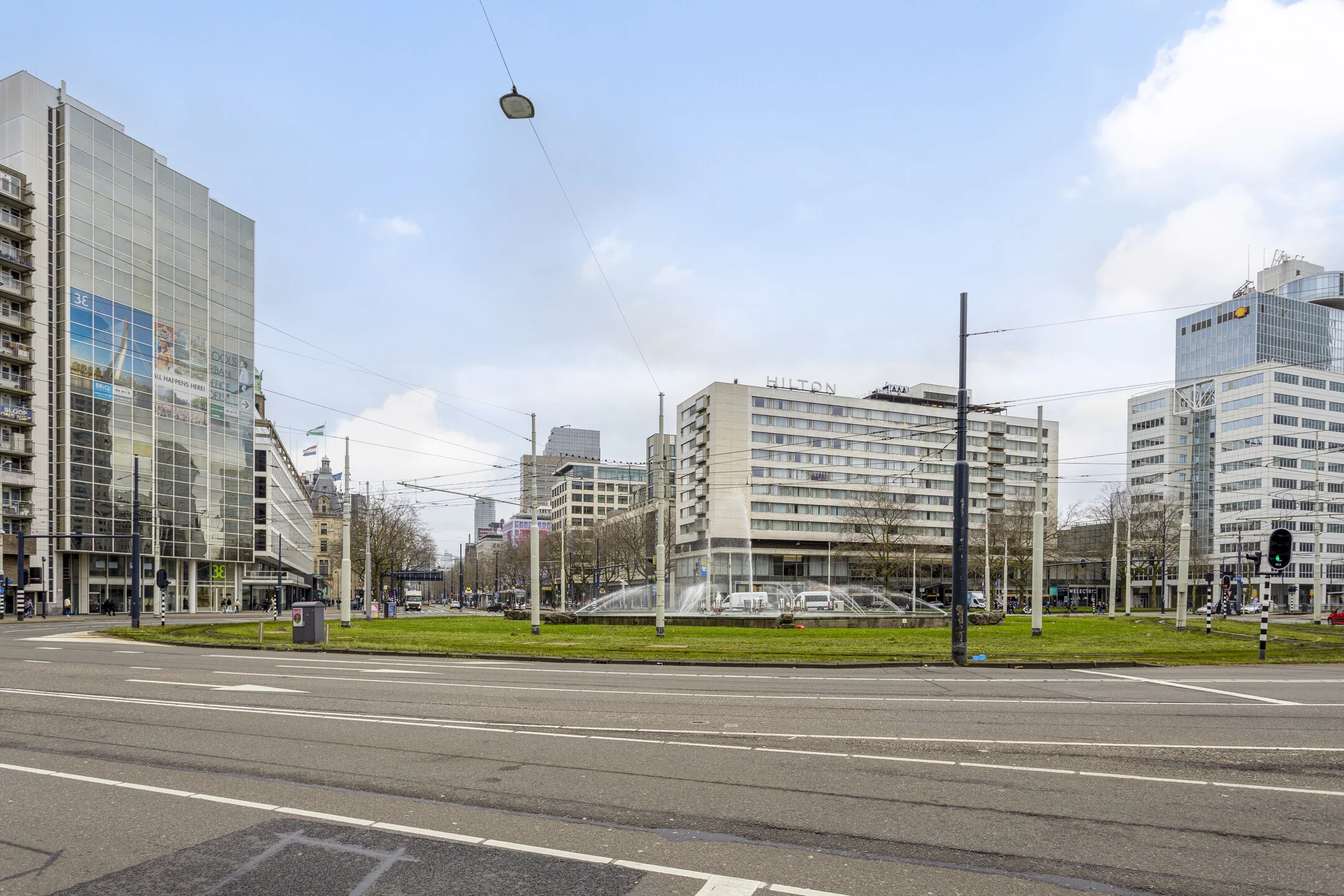 Uitzicht op het Hofplein in Rotterdam met omliggende moderne gebouwen en de bekende fontein.