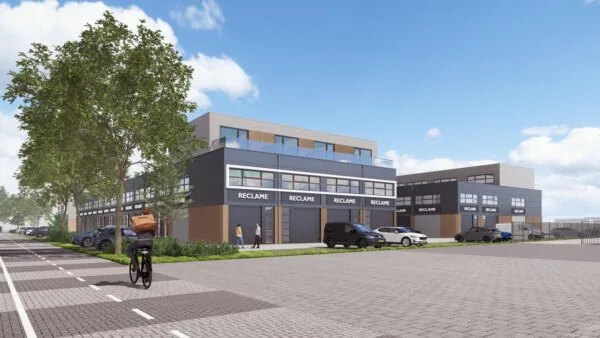 Moderne bedrijfsunits aan De Liesbosch met parkeerplaatsen, groenstrook en een fietser op de voorgrond.