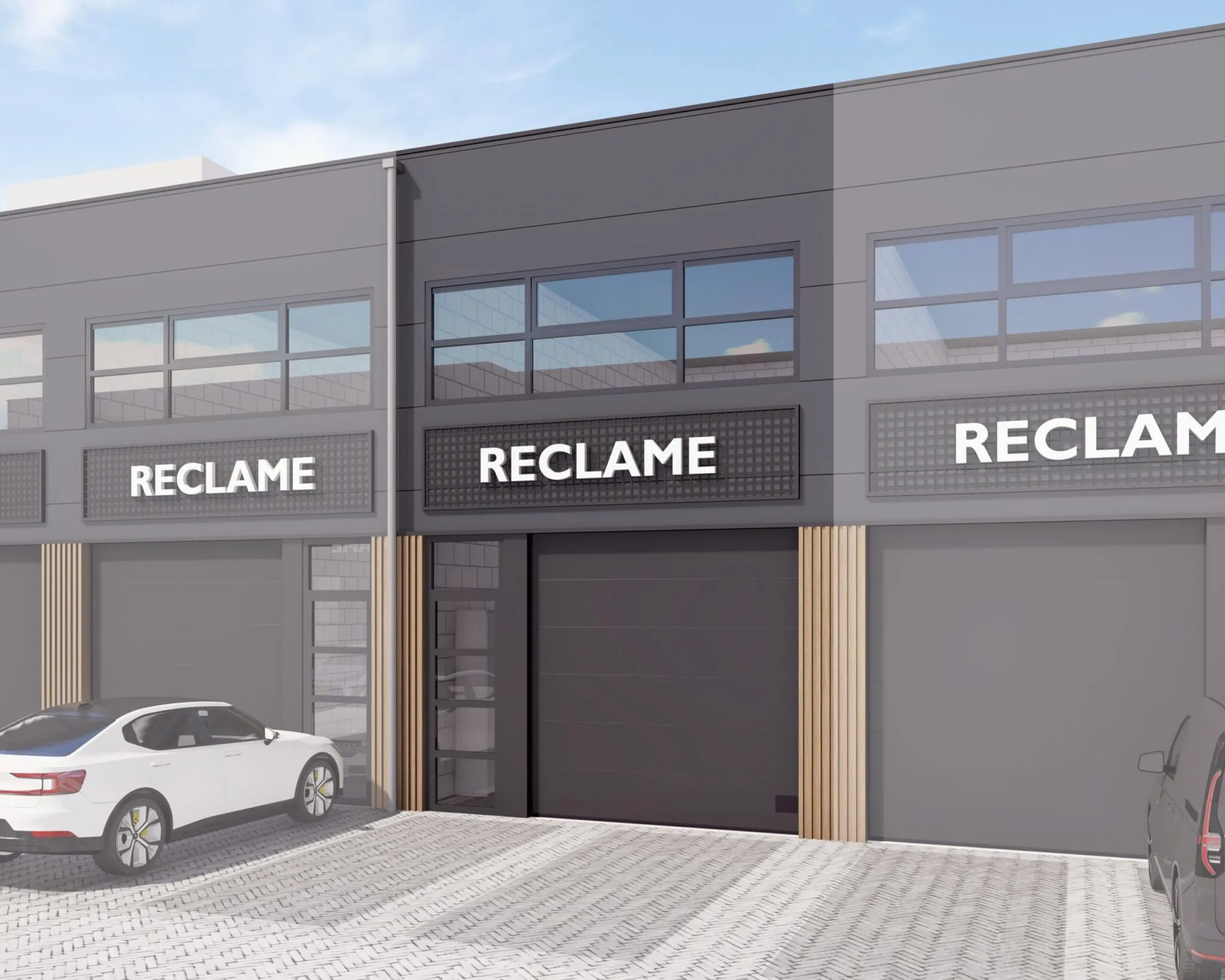 Moderne bedrijfsunits met zwart-grijze gevel en reclameborden aan De Liesbosch, met geparkeerde auto's op de voorgrond.