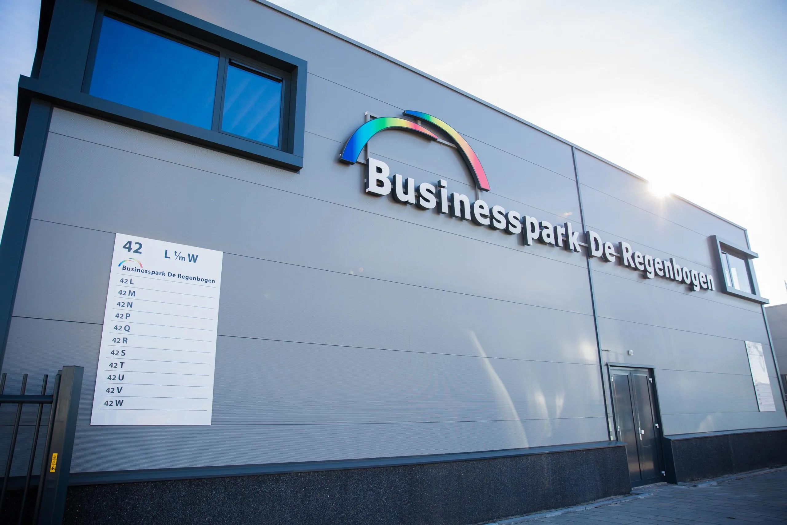 Voorgevel van een modern bedrijfsgebouw met het logo en de naam 'Businesspark De Regenbogen' aan de Laan van ’s-Gravenmade.