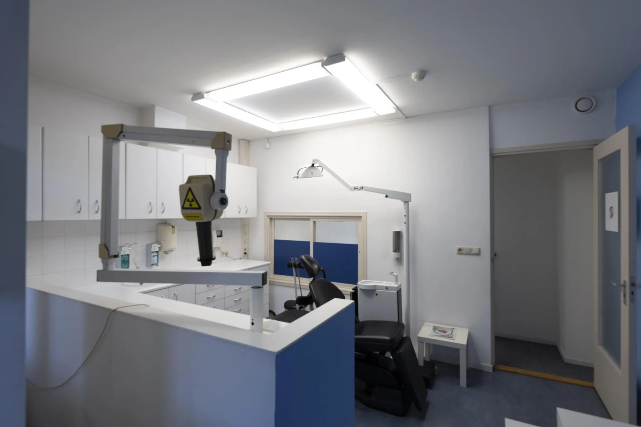 Behandelkamer in een tandartspraktijk aan de Overtoom met tandartsstoel, röntgenapparaat en medische apparatuur.