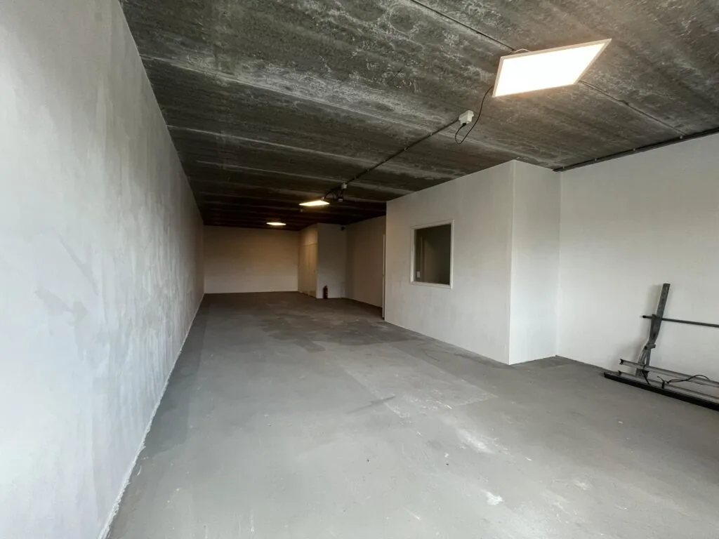 Een lege, kale ruimte met betonvloer en witte muren op Broekdijk West.