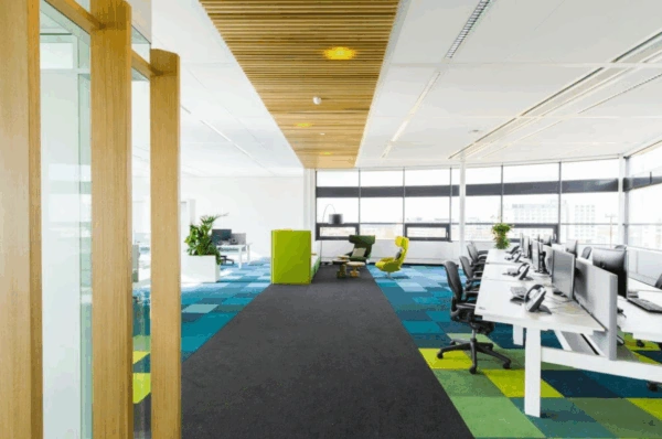 Modern en licht kantoorinterieur aan de Boeing Avenue met flexwerkplekken, kleurrijke vloerbedekking en loungehoek.