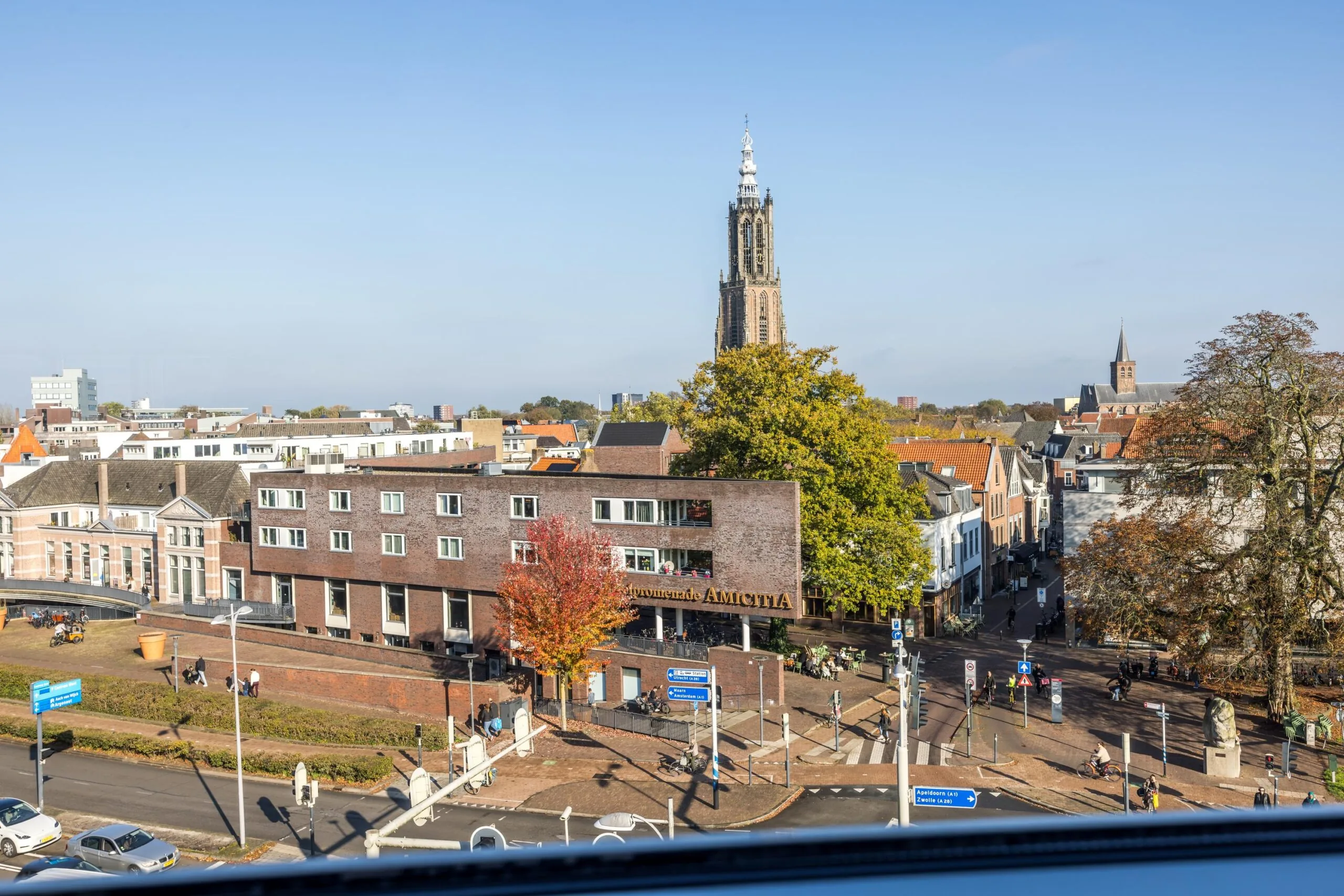 Stadsgezicht op de Arnhemseweg in Amersfoort met de Onze-Lieve-Vrouwetoren prominent op de achtergrond.