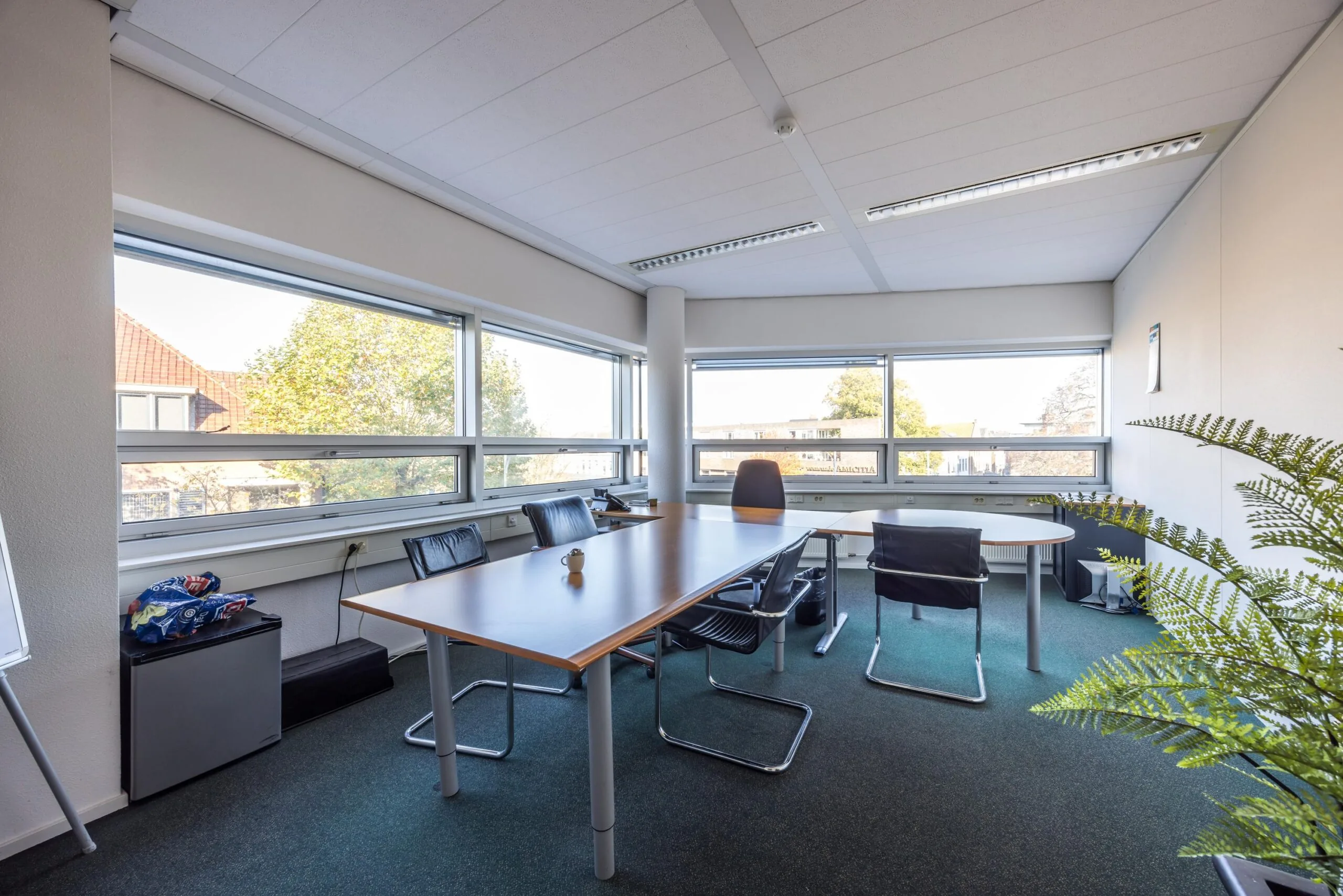 Licht en ruim kantoor met vergadertafel en bureaustoel aan de Arnhemseweg.