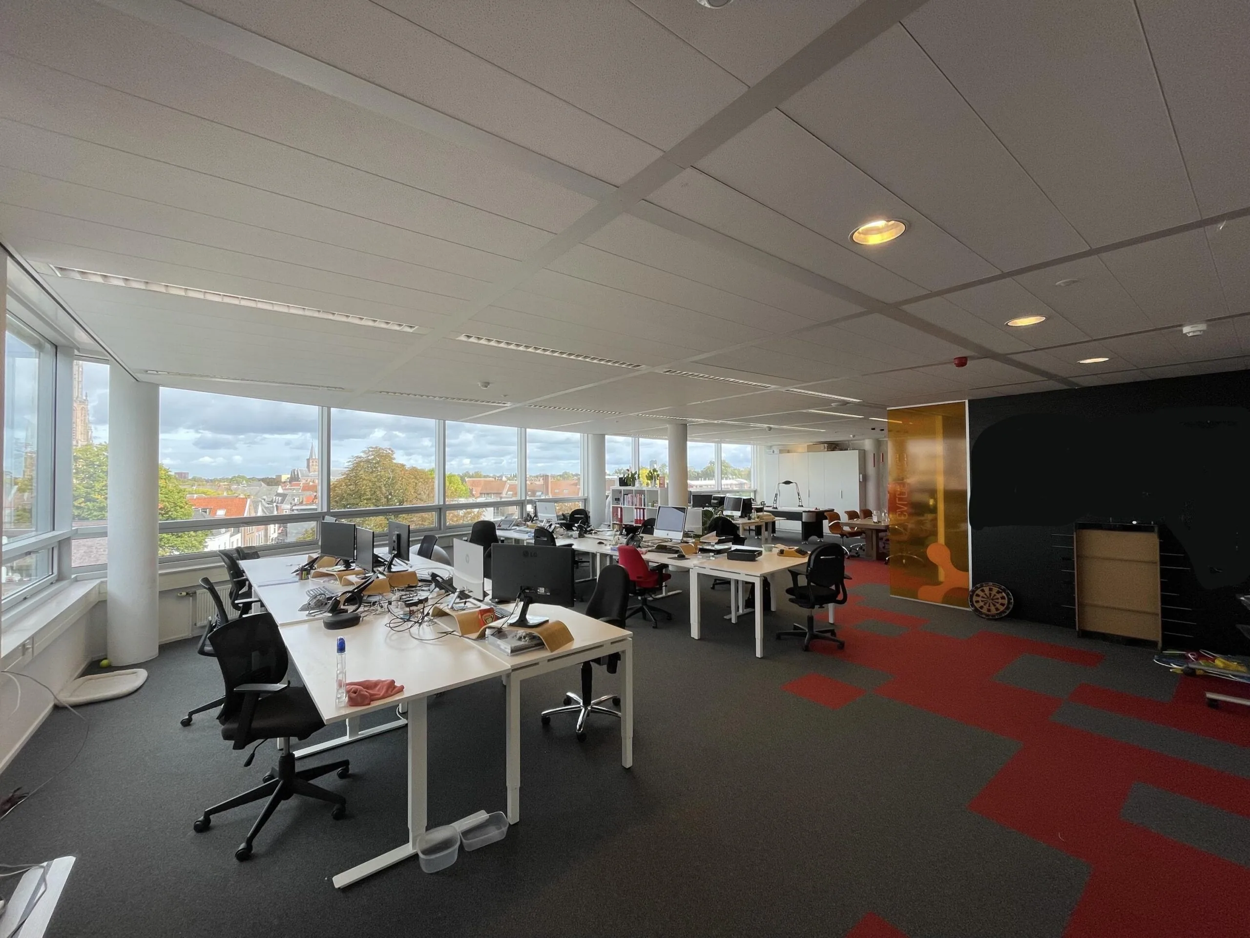 Modern kantoorinterieur aan de Arnhemseweg met werkplekken, grote ramen en uitzicht over de stad.