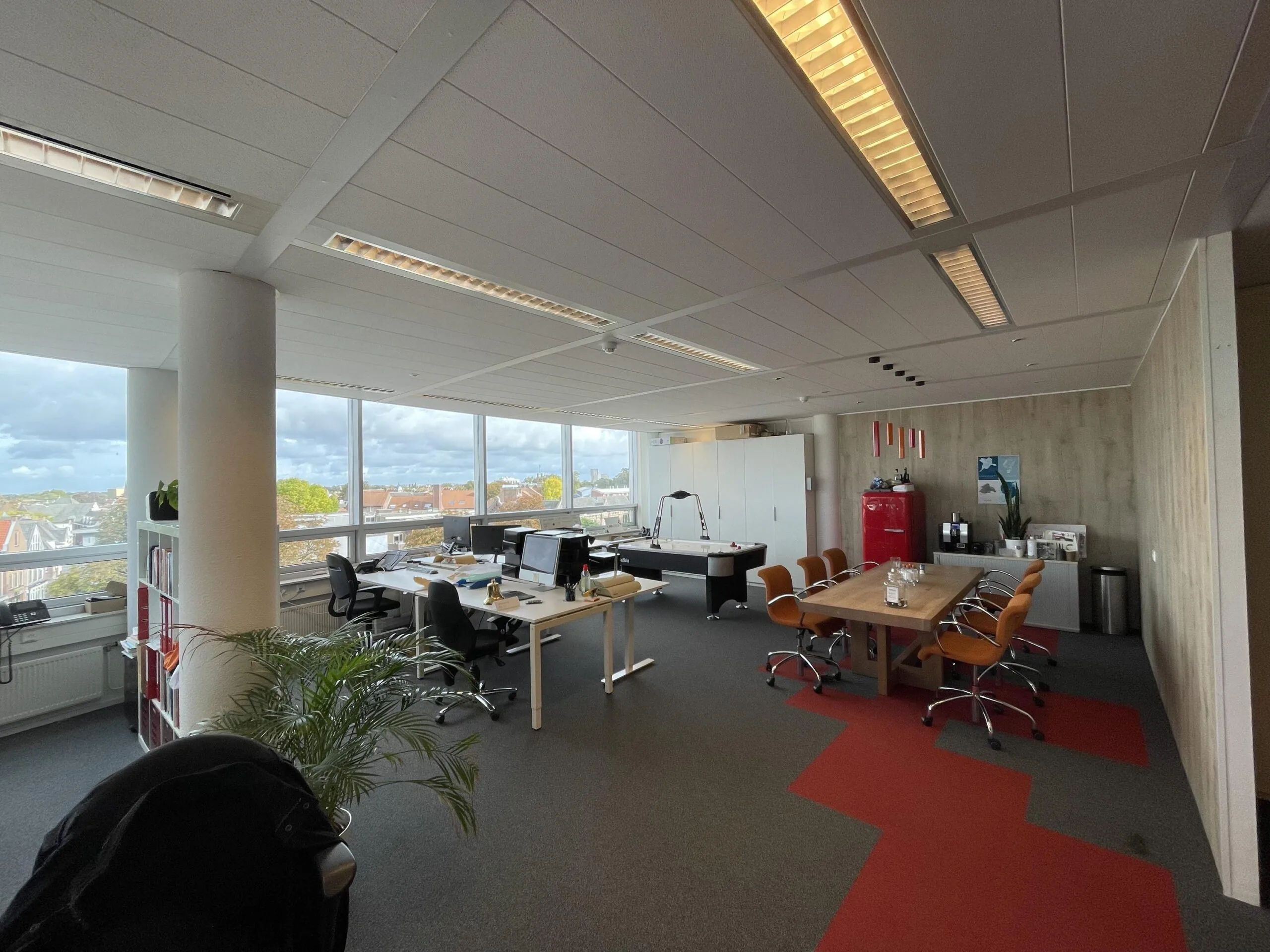 Modern kantoor aan de Arnhemseweg met werkplekken, vergadertafel, grote ramen en uitzicht over de stad.