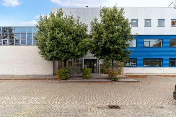 Vooraanzicht van een kantoorgebouw aan de Zuiderweg met blauwe gevel en twee grote bomen bij de entree.
