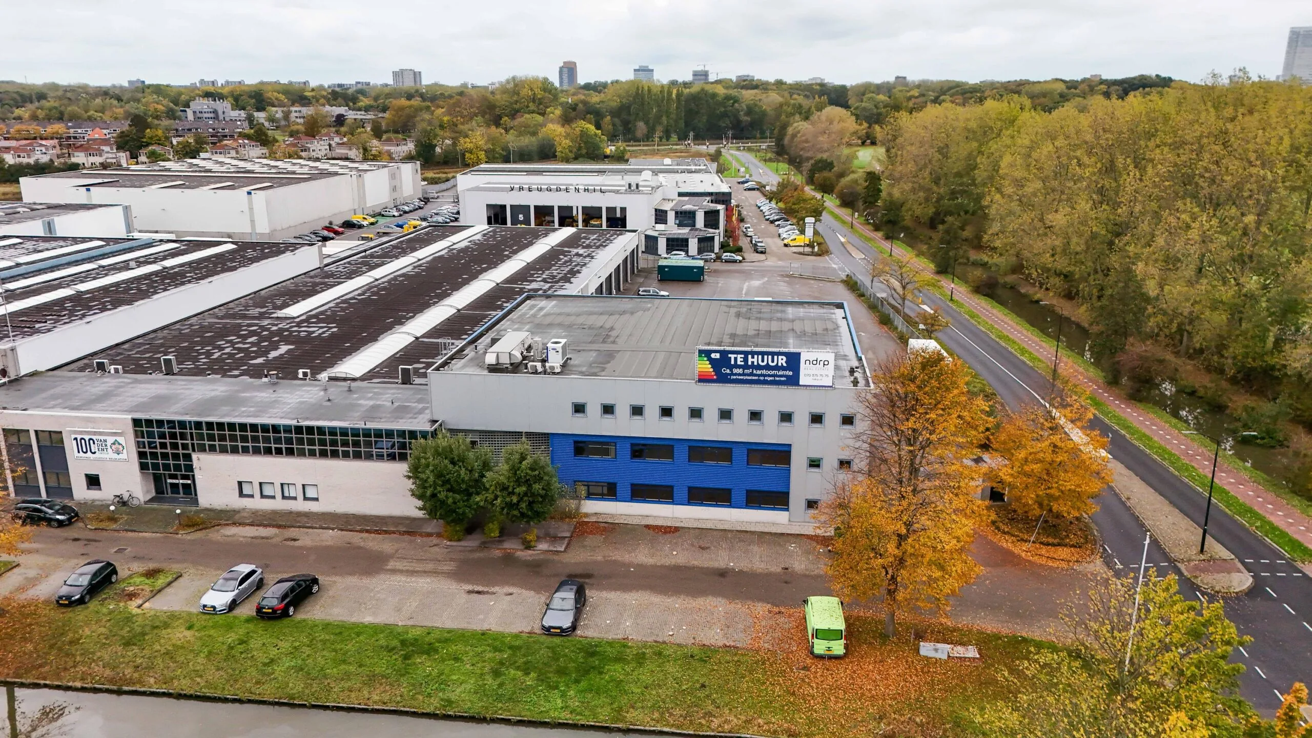 Luchtfoto van een bedrijventerrein aan de Zuiderweg met een kantoorpand waarop een "Te Huur" bord zichtbaar is.