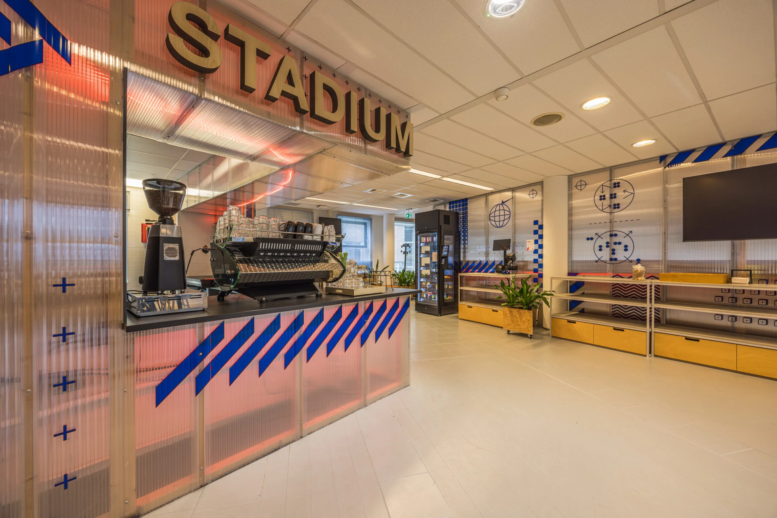 Modern coffee bar named "Stadium" with industrial design elements and colorful geometric wall decorations.