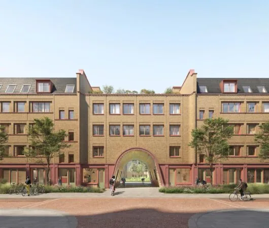 Modern apartment building on Zaanstraat with a central archway and people walking and cycling in front.
