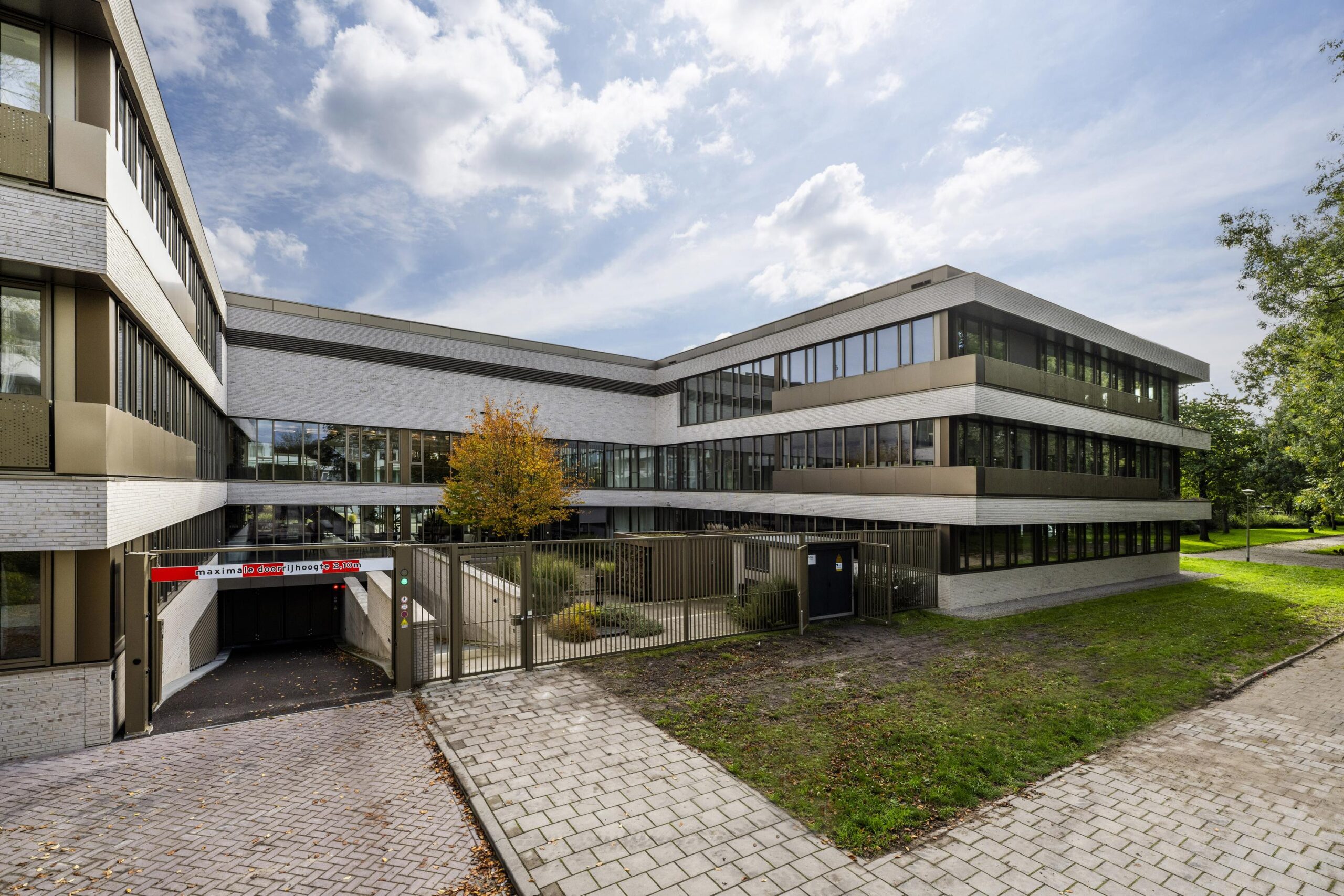 Modern office building "Walborg" with large glass windows and a gated underground parking entrance.