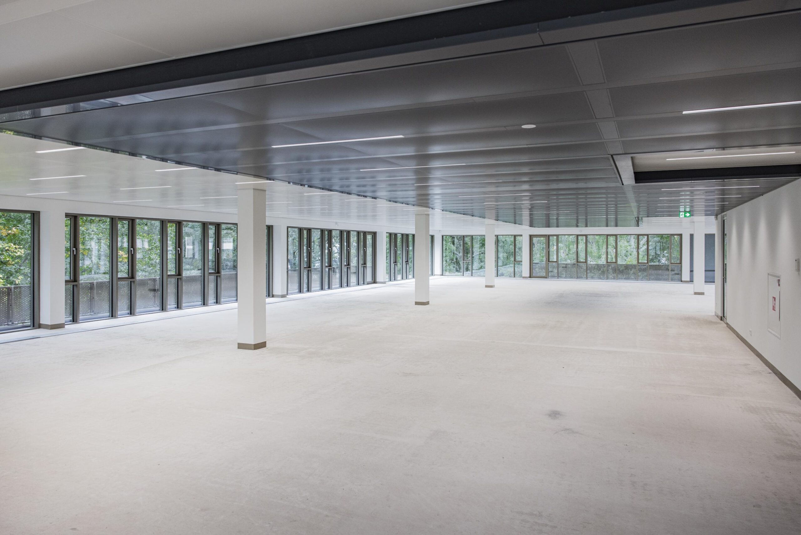 Spacious empty office floor with large windows and modern ceiling at Walborg 2 building.