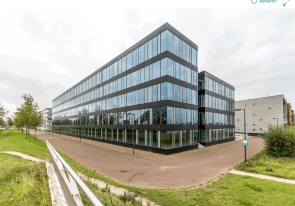 Modern glass office building on Pedro de Medinalaan in Amsterdam, viewed from the street corner.