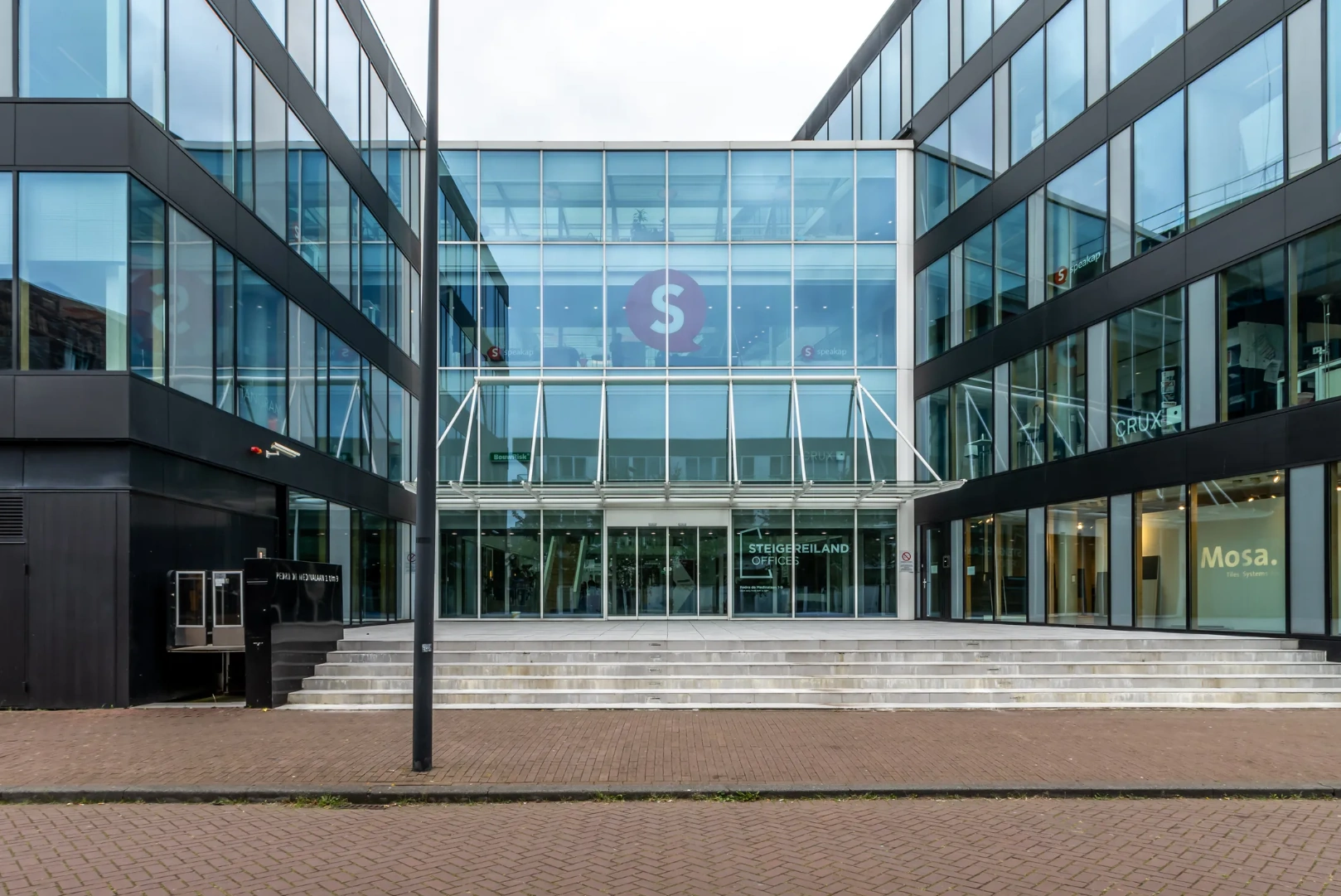 Modern office building entrance at Pedro de Medinalaan with glass facade and Steigereiland Offices signage.