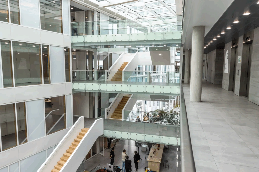 Modern multi-level office interior with glass railings, staircases, and an open atrium at Pedro de Medinalaan.