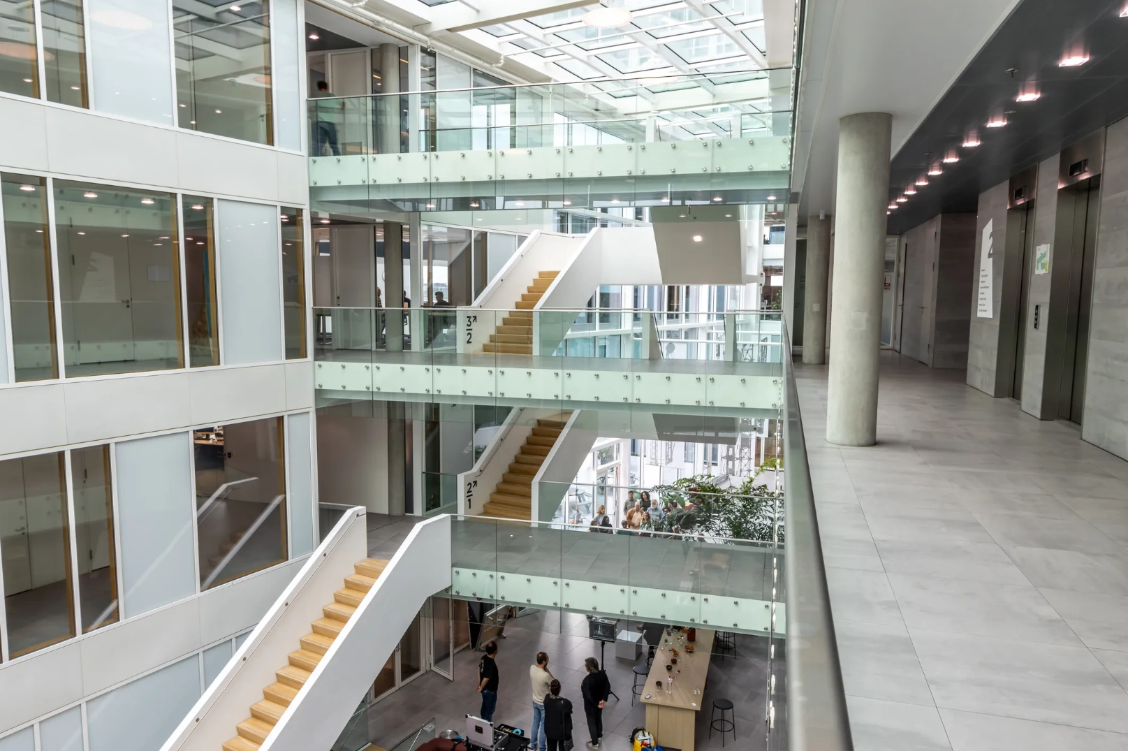 Modern multi-level office interior with glass railings, staircases, and an open atrium at Pedro de Medinalaan.