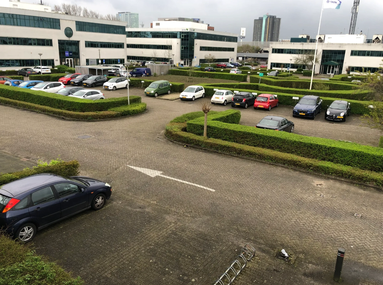 Office buildings and a parking lot with cars at Zekeringstraat in an urban business district.