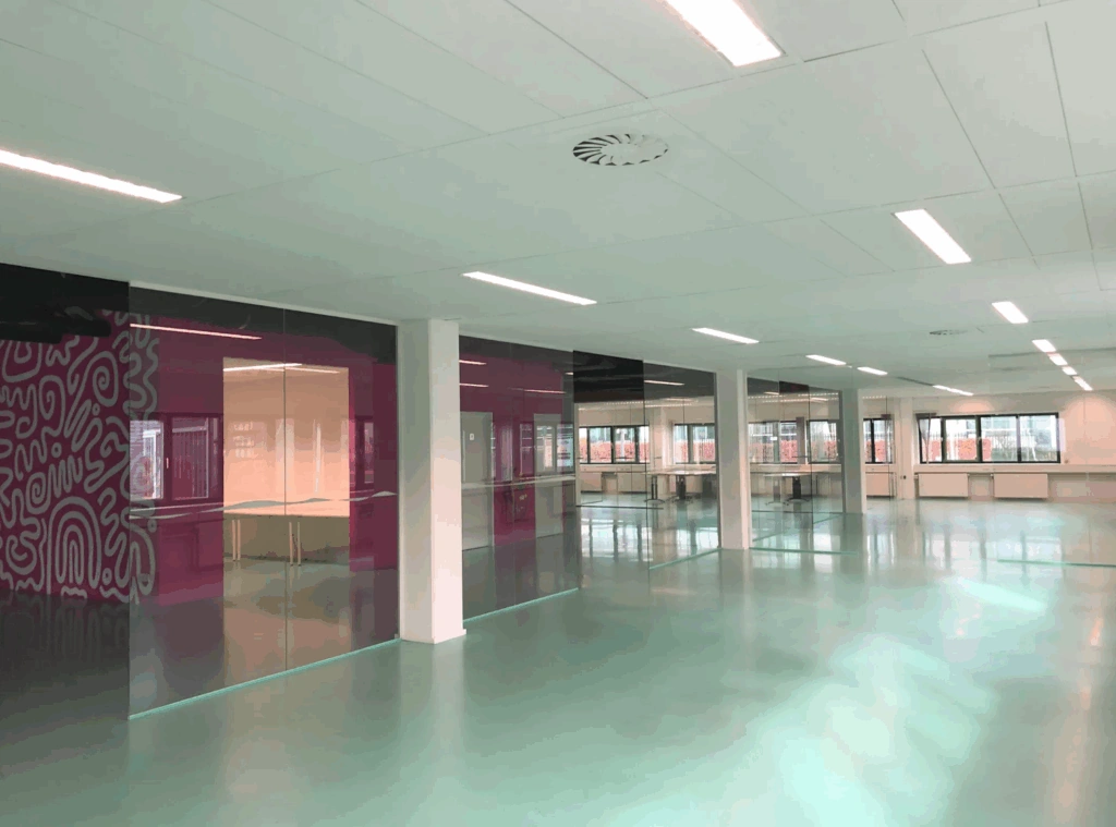 Modern empty office space at Zekeringstraat with glossy floors, glass walls, and colorful accents.