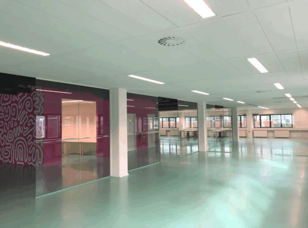 Modern empty office space at Zekeringstraat with glossy floors, glass walls, and colorful accents.