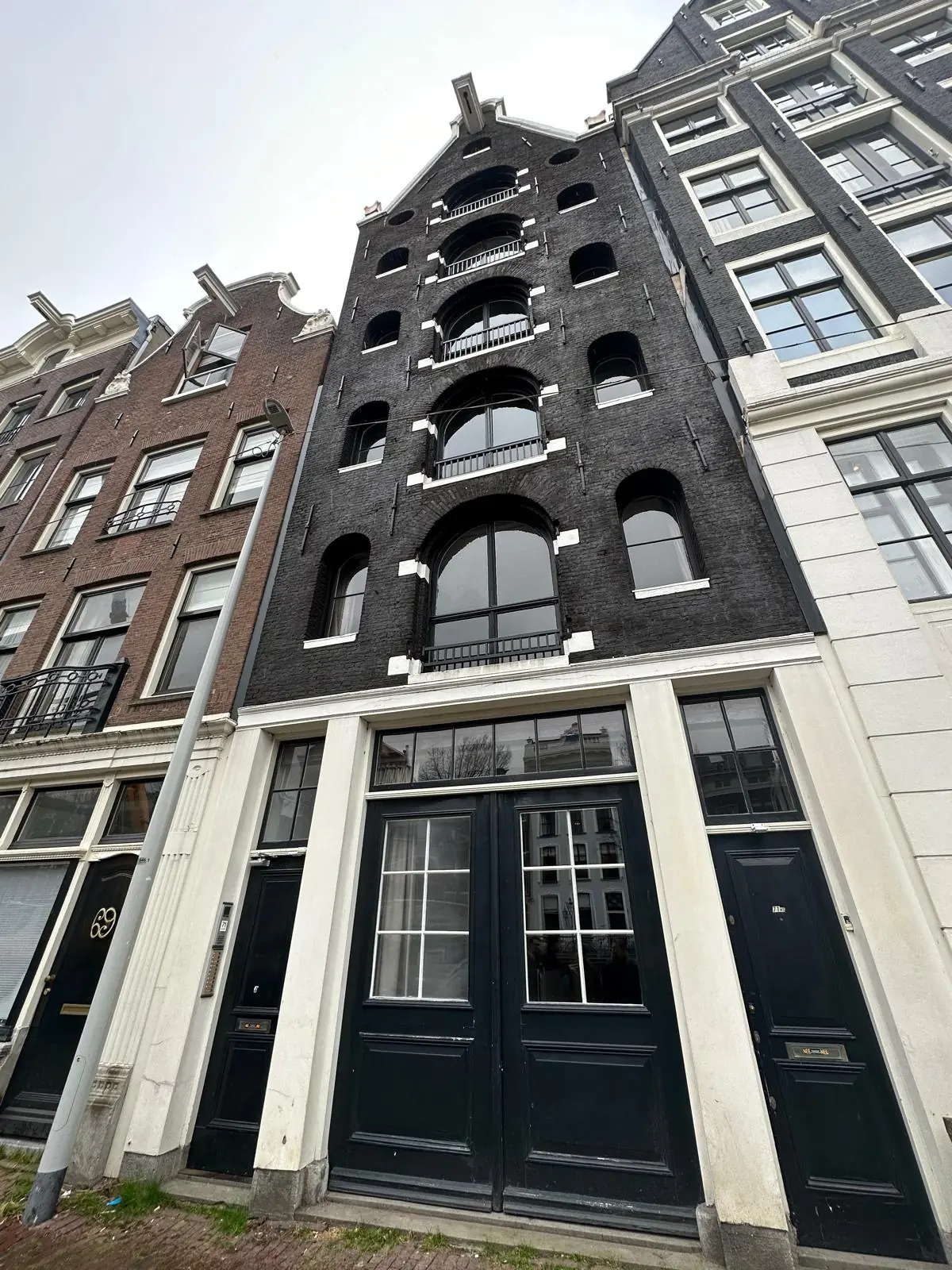 Historic canal house at Herengracht 176 in Amsterdam with a black brick facade and arched windows.