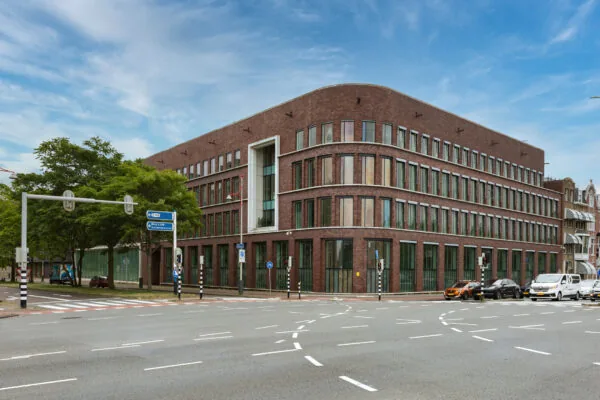 Modern brick office building on Carel van Bylandtlaan at a busy intersection in The Hague.