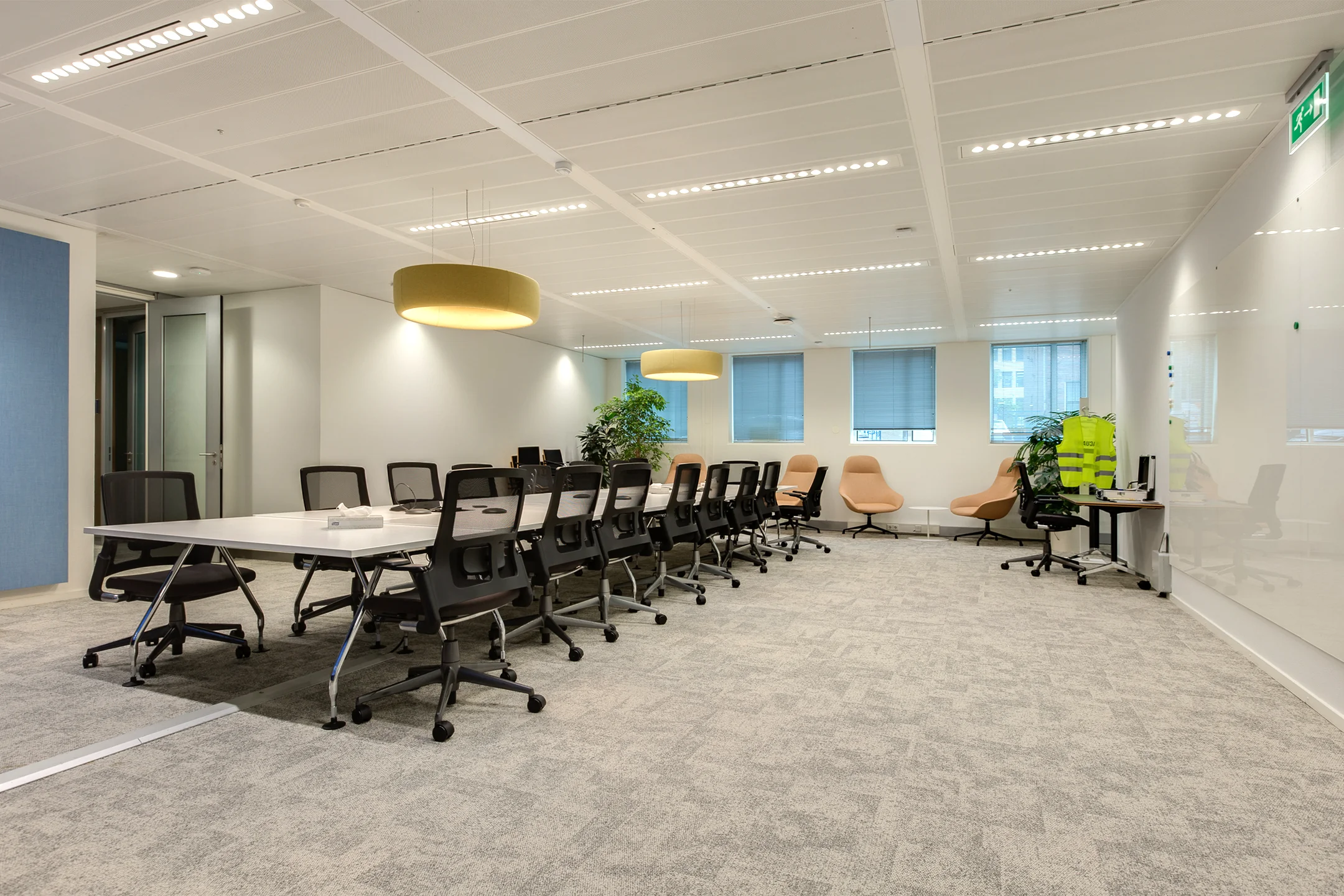 Modern conference room on Carel van Bylandtlaan with a long meeting table, office chairs, and lounge seating.