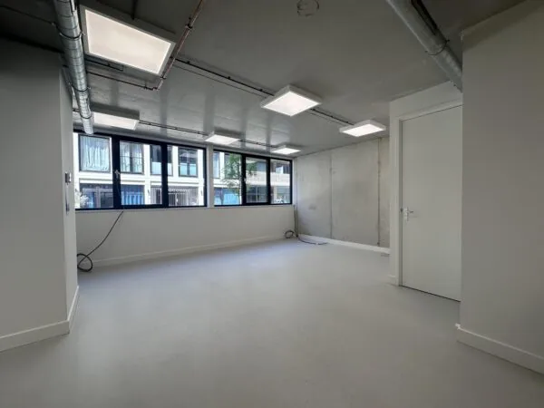 Empty modern office space on Willem Parelstraat with large windows and industrial-style ceiling.