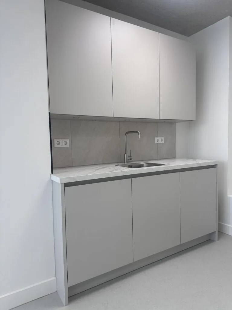 Modern grey kitchenette with built-in cabinets and a marble countertop in Willem Parelstraat.