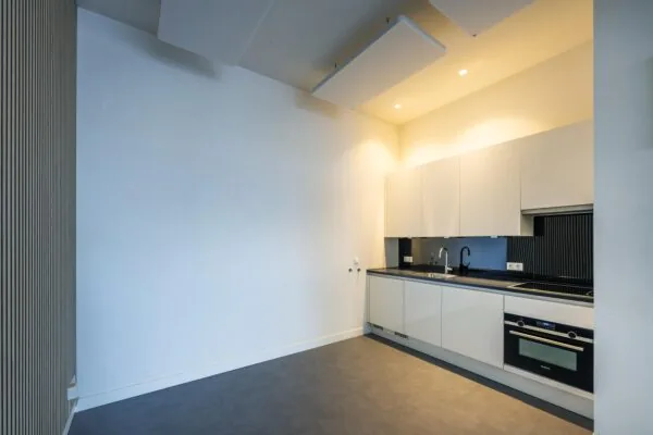 Modern white kitchen in an apartment on James Wattstraat with built-in appliances and minimalist design.