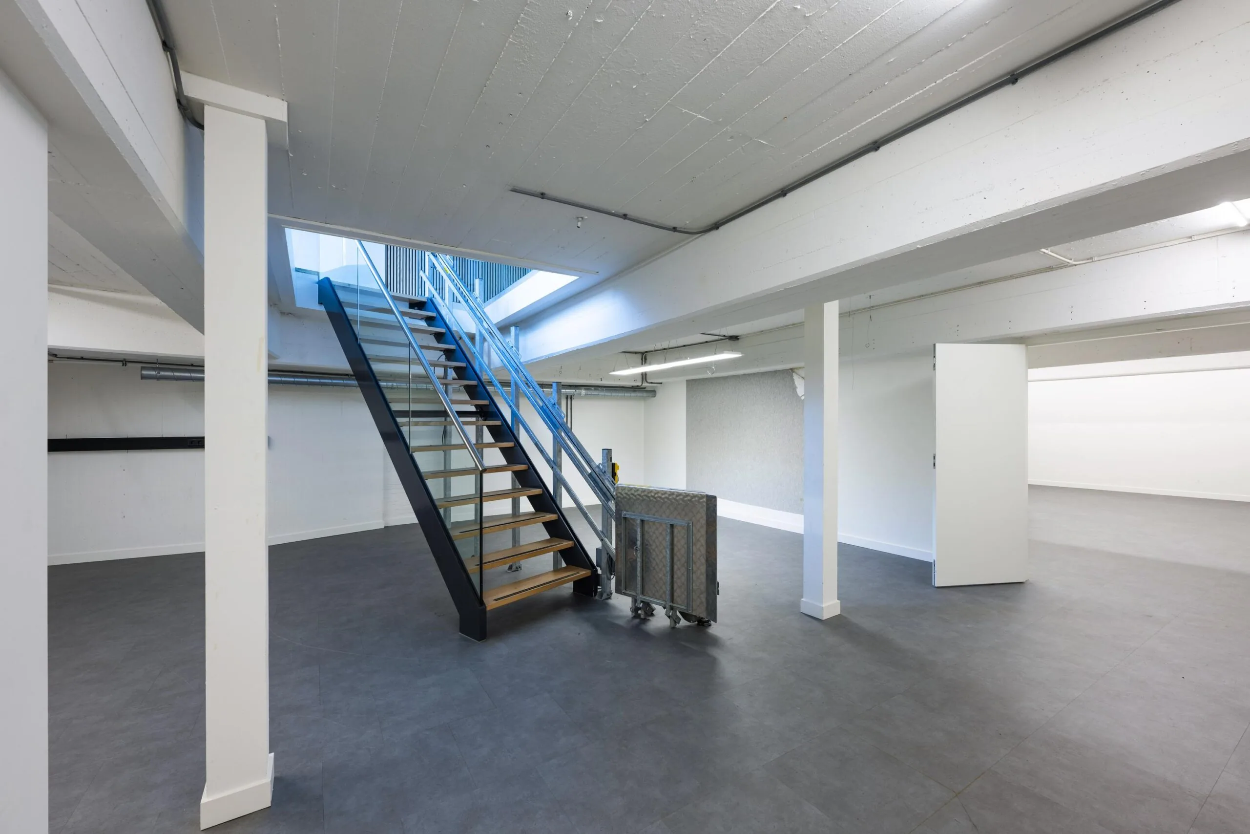 Modern industrial interior with a central staircase and open workspace in James Wattstraat.